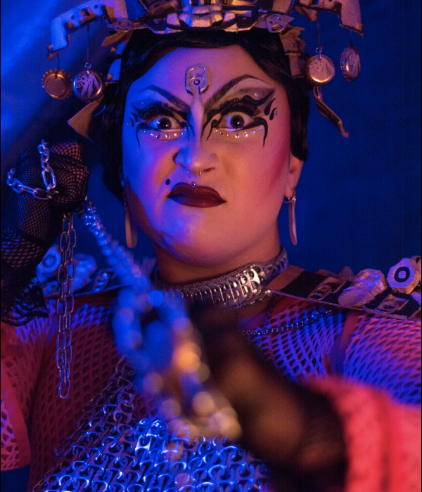 image représentant une drag Queen dans une lumière chaude/bleu avec une chaine nous menaçant